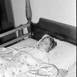 Person resting on a vintage bed