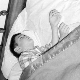 Person sleeping under sheet near map