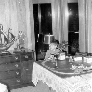 Child with model train indoors