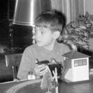 Child with model train indoors