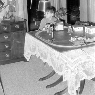 Child with model train indoors