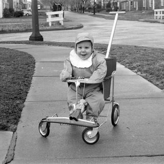 Child riding wheeled cart outdoors