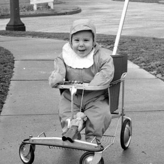 Child riding wheeled cart outdoors