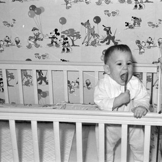 Baby in Mickey Mouse nursery crib