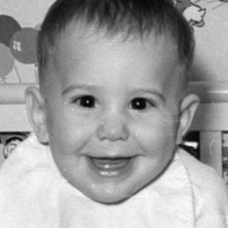 Baby in Disney-themed crib smiling