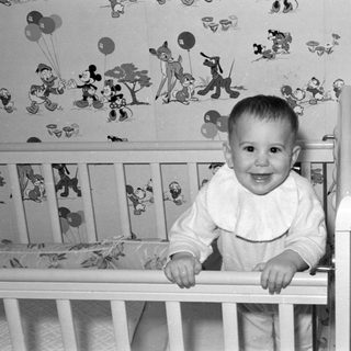 Baby in Disney-themed crib smiling