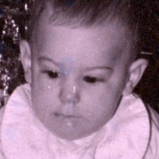 Child with toy dog by Christmas tree