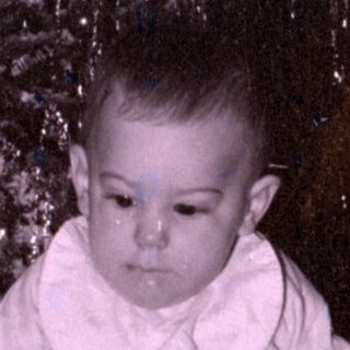 Child with toy dog by Christmas tree