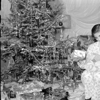 Woman and baby by Christmas tree