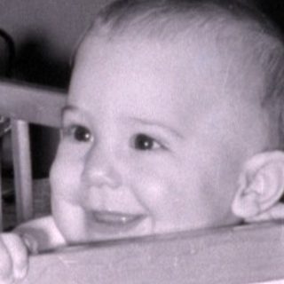 Baby smiling in vintage crib