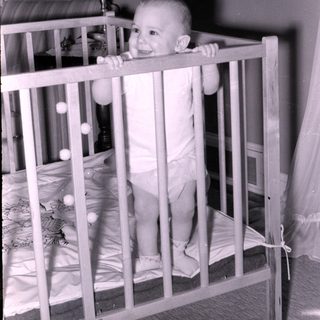 Baby smiling in vintage crib