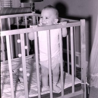 Baby smiling in vintage crib