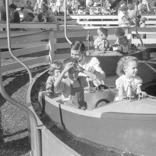 Children riding a boat attraction at an amusement park.
