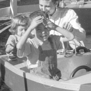 Children riding a boat attraction at an amusement park.