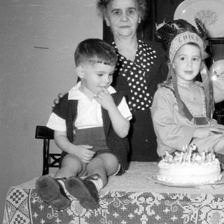Family group with a cake and child in costume.