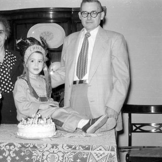 Family group with a cake and child in costume.