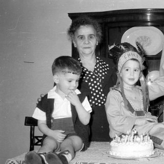 Family group with a cake and child in costume.