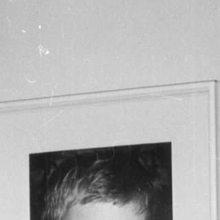 Child sitting next to a framed portrait.
