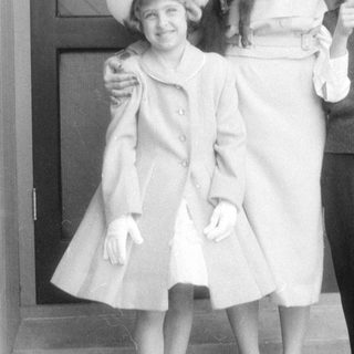 Woman and two children in formal mid-century attire.