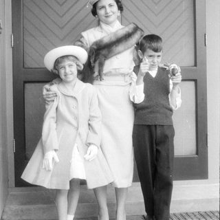 Woman and two children in formal mid-century attire.