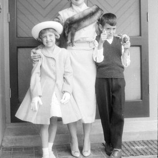 Woman and two children in formal mid-century attire.