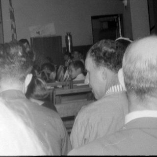 People seated in an audience facing a dark stage.
