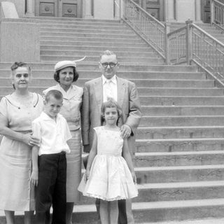 Family group posing on wide stone stairs.