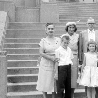 Family group posing on wide stone stairs.