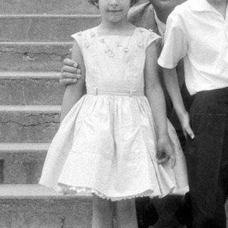 Man and three children on concrete stairs.