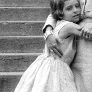Woman and young girl standing on stone stairs.