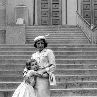 Woman and young girl standing on stone stairs.