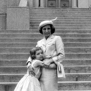 Woman and young girl standing on stone stairs.