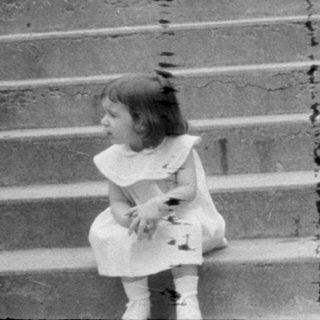 Woman and two children on wide stone stairs.