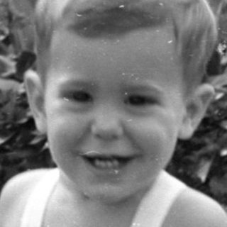 Upside-down black and white photo of a young child.
