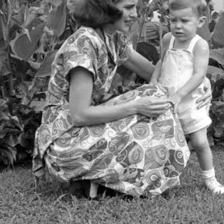 Woman and child in a garden with fountain.