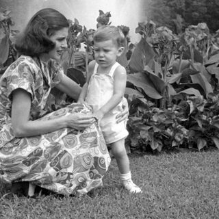 Woman and child in a garden with fountain.