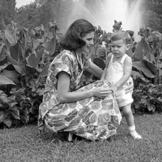 Woman and child in a garden with fountain.