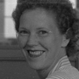 Woman at a typewriter in a mid-century office.