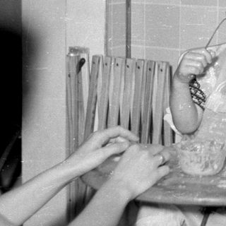 Toddler in high chair with food on face.