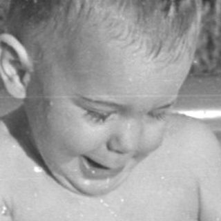 Young child splashing in an inflatable swimming pool.