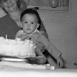 Woman and toddler with a first birthday cake.