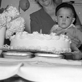 Woman and toddler with a first birthday cake.