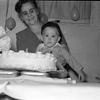 Woman and toddler with a first birthday cake.