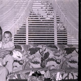 Man and baby sitting on a patterned sofa.