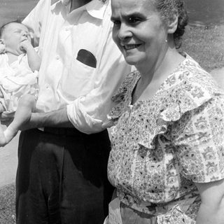 Man and woman holding a baby outdoors.