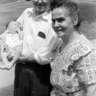 Man and woman holding a baby outdoors.