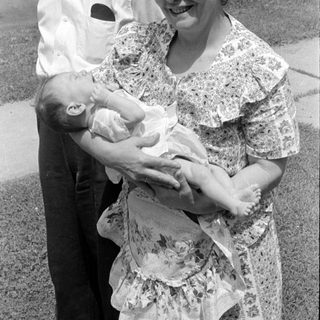 Man and woman with an infant outdoors.