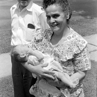 Man and woman with an infant outdoors.