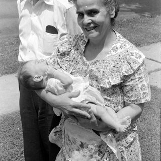 Man and woman with an infant outdoors.