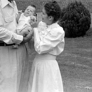 Man and woman with an infant outdoors.